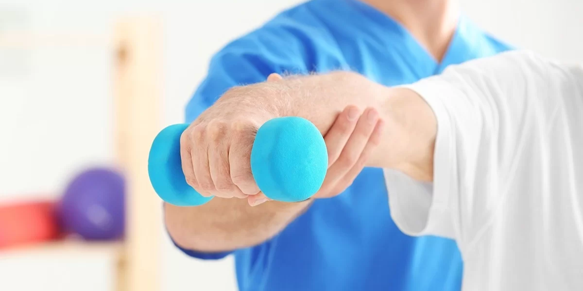 Profissional ajudando um paciente com dor crônica a fazer exercícios